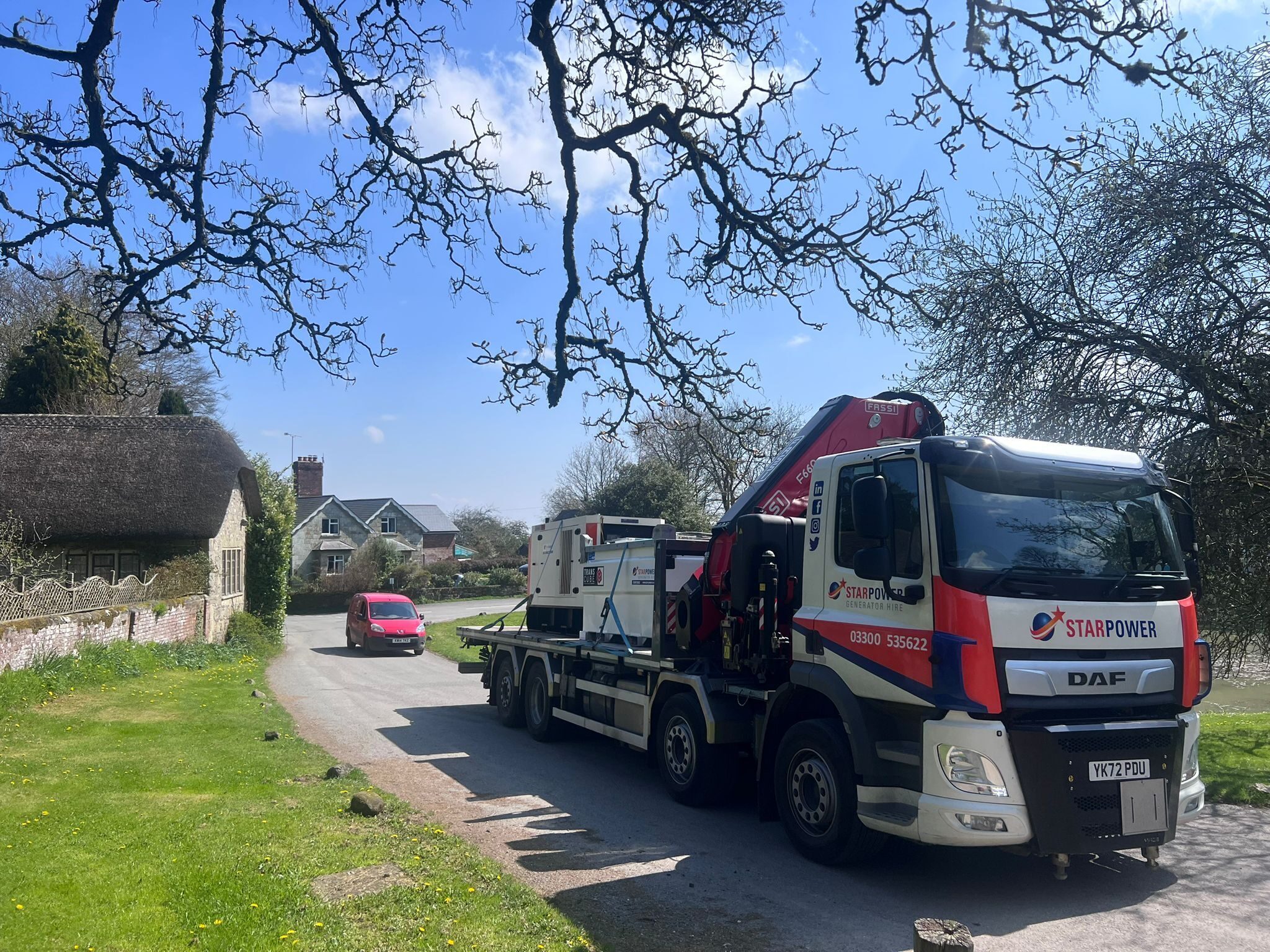 A Star Power delivery lorry driving through a village carrying two generators
