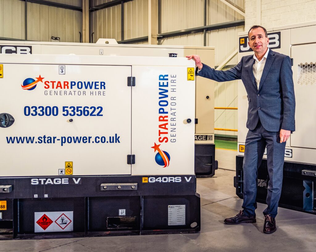 Man standing next to Star Power Stage V and JCB generators.